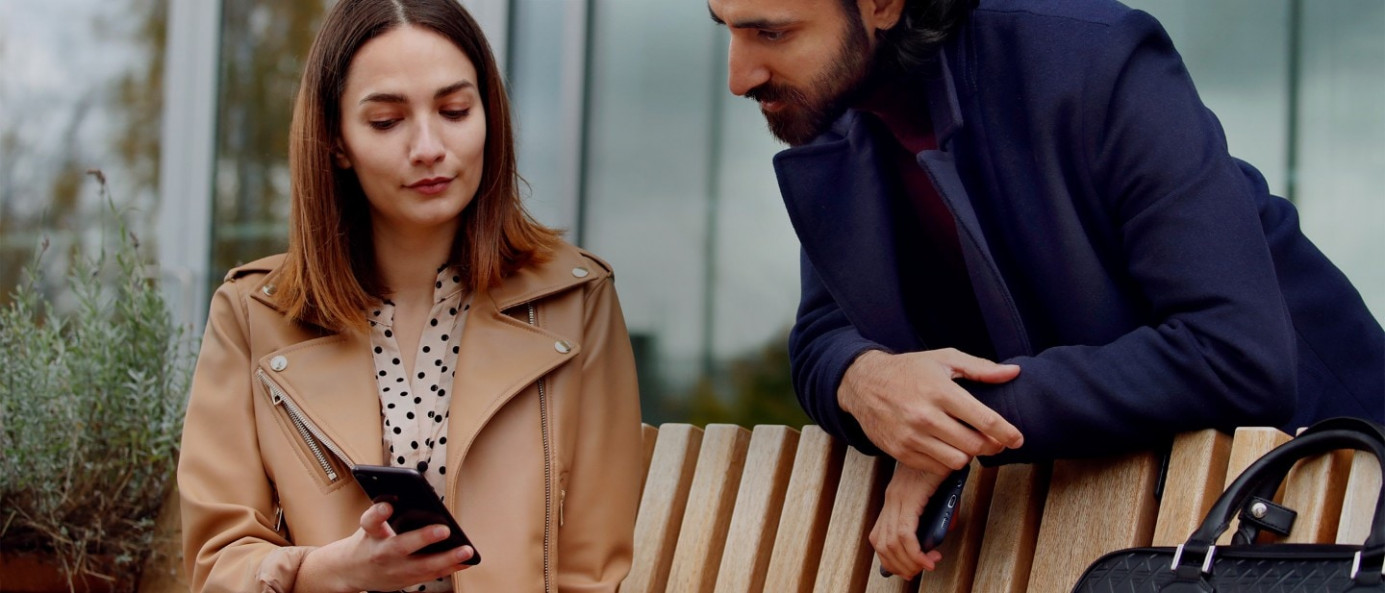 Zwei Personen schauen auf ein Handy - IMMER FÜR SIE DA